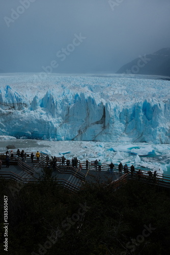 Wallpaper Mural Tourists admire the massive blue ice walls of Perito Moreno Glacier from a viewpoint, with floating ice blocks on the turquoise lake, panoramic glacier views in El Calafate, Patagonia, Argentina. Torontodigital.ca