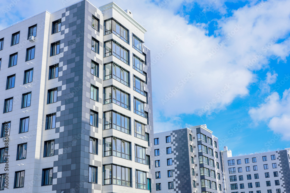 The concept of a multi-storey lady, a residential complex. A view from below of the houses of the residential complex, which stand one after the other three houses, houses of modern architecture with The concept of a multi-storey lady, a residential complex. A view from below of the houses of the residential complex, which stand one after the other three houses, houses of modern architecture with