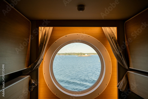 Foto Scenic sea view through porthole from cozy cruise ship cabin interior window