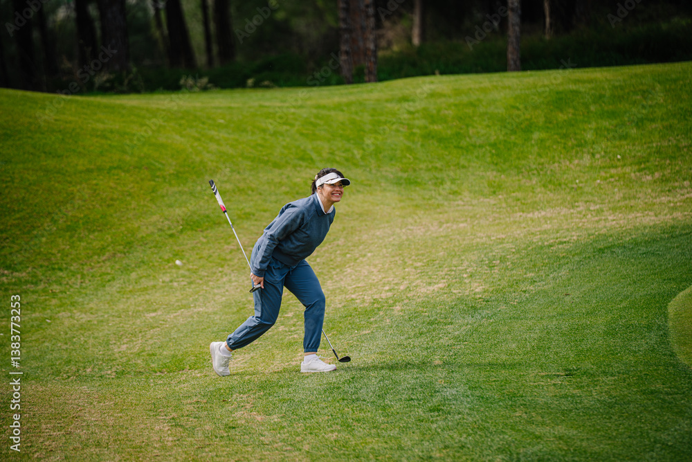 A smiling female golfer in blue attire and visor bends forward on a green fairway holding a golf club, enjoying her game on a sunny day.. A smiling female golfer in blue attire and visor bends forward on a green fairway holding a golf club, enjoying her game on a sunny day..