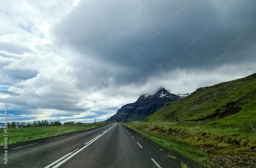 Naklejka premium Highway leading to snow capped mountain in Iceland under cloudy sky