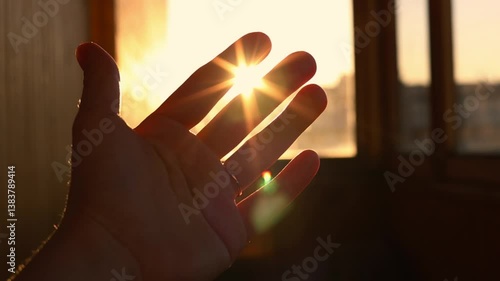 female hand playing with sunlight glare coming through window