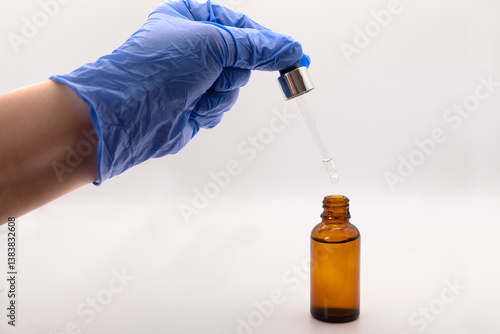 Hand of a health worker holding a pipette with serum