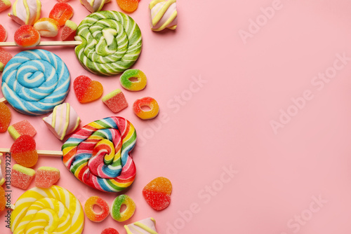 Obraz na płótnie Many different tasty candies and marshmallows on pink background, flat lay. Space for text w salonie