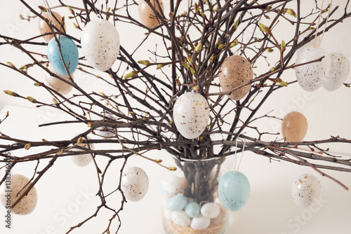 Obraz na płótnie Easter tree decorated colorful pastel white and beige eggs. Birch branches with hang eggs in vase on white table. Close up w salonie