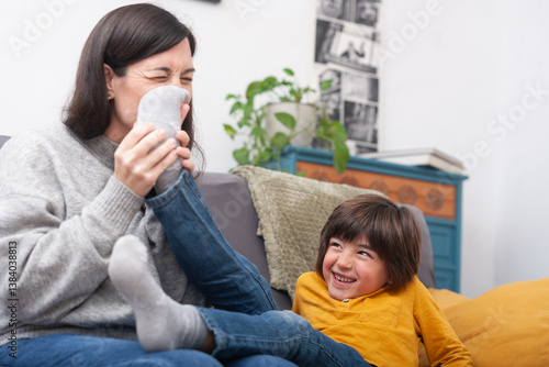 Bild auf Leinwand Laughing boy as mom takes off his socks