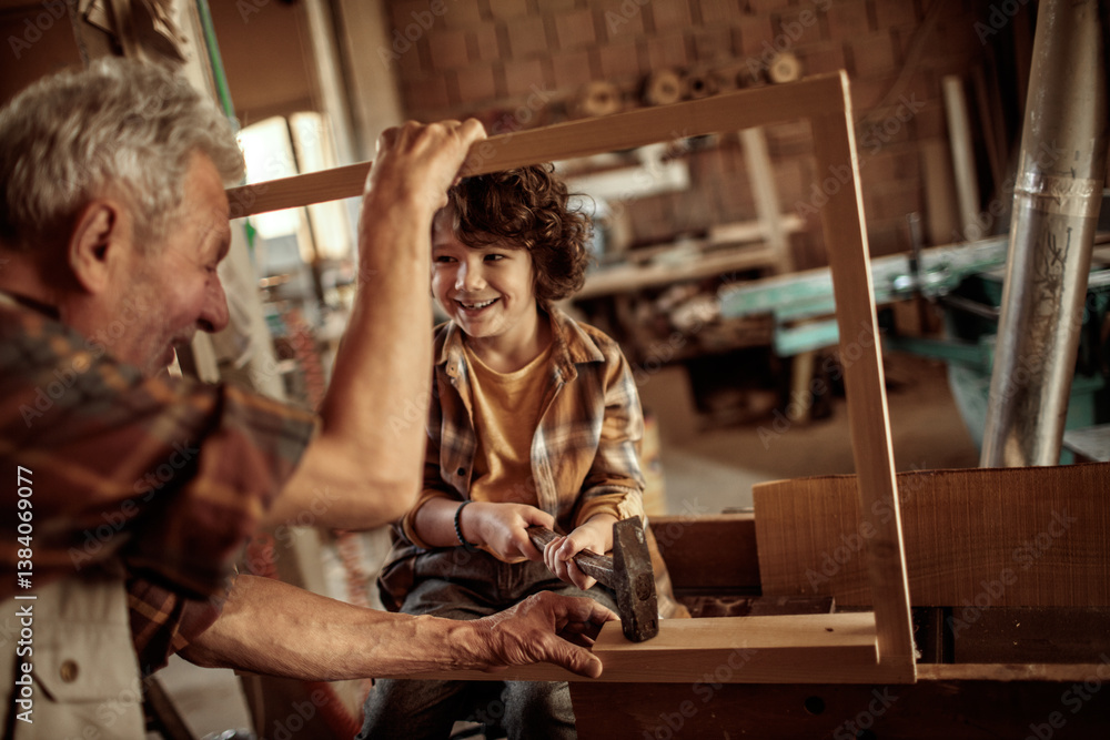 Grandfather teaching grandson woodworking in carpentry workshop Grandfather teaching grandson woodworking in carpentry workshop