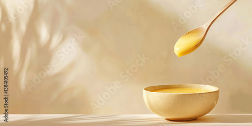 Natural yellow Ghee clarified butter in a bowl and on a spoon. Healthy natural organic product.