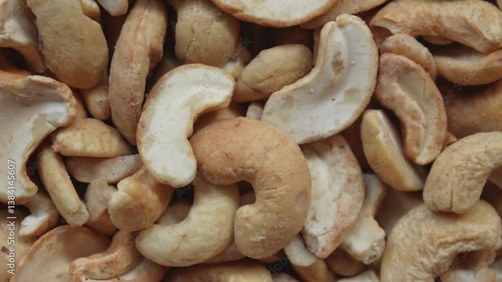 Roasted cashew nuts cracking close-up. Crispy texture and warm beige tones Roasted cashew nuts cracking close-up. Crispy texture and warm beige tones