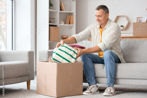 Mature man unpacking box wi...
