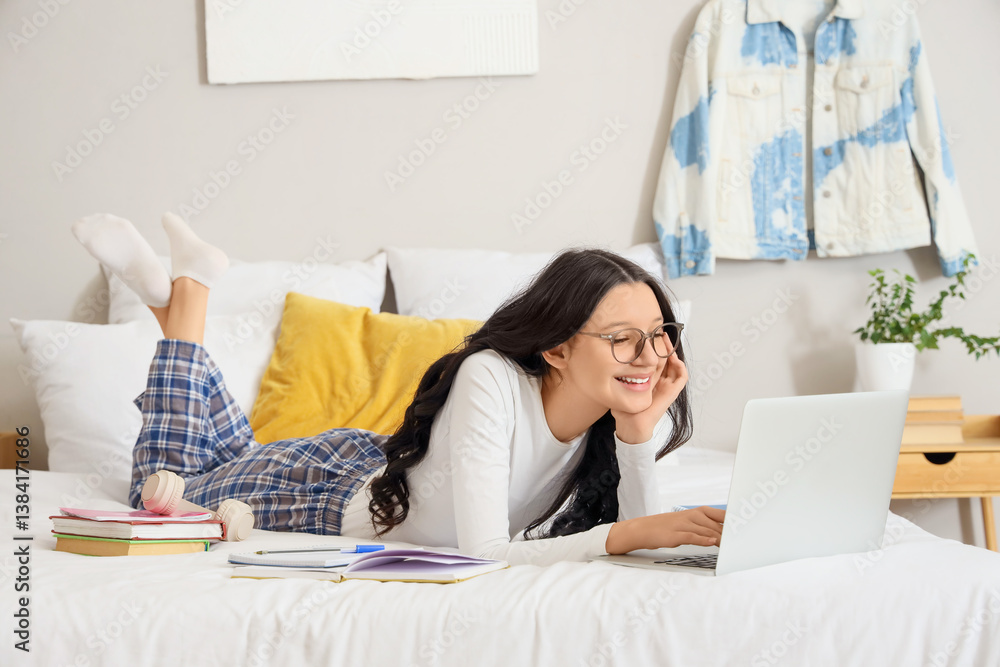 Teenage girl with laptop working online in bedroom Teenage girl with laptop working online in bedroom