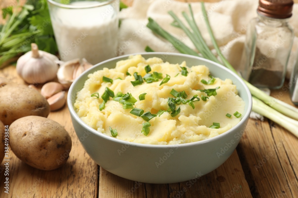 Delicious mashed potato with green onions on wooden table, closeup Delicious mashed potato with green onions on wooden table, closeup