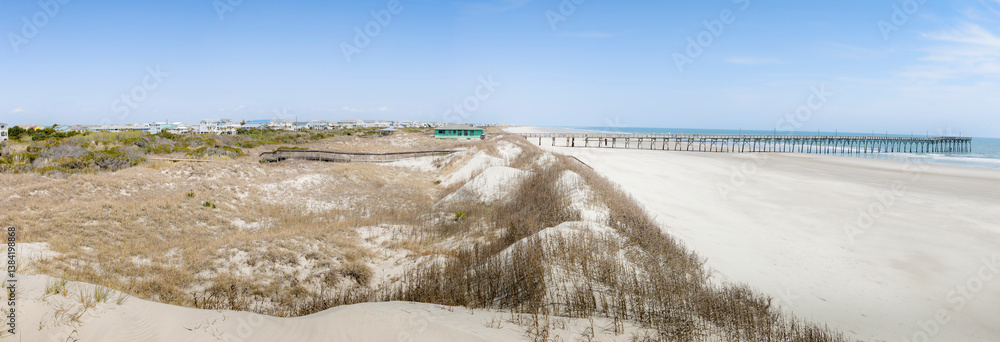 Panoramic style photograph of classic Eastern Coast beach with features including pier and homes