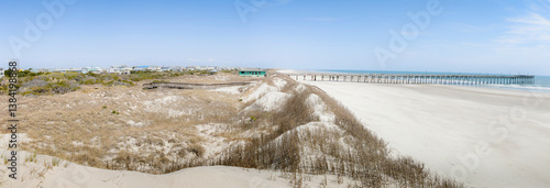 Panoramic style photograph of classic Eastern Coast beach with features including pier and homes