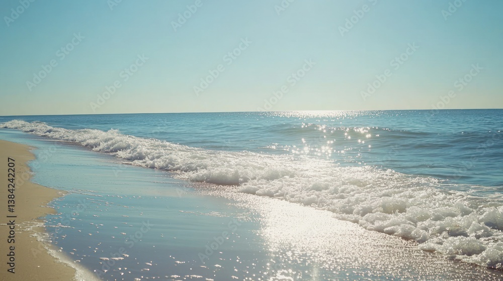 Fototapeta premium A beautiful beach with waves and shimmering sunlight is visible