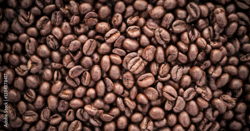 Freshly roasted coffee beans fill the frame. Classic background view from above. Premium background for coffee processing products.
