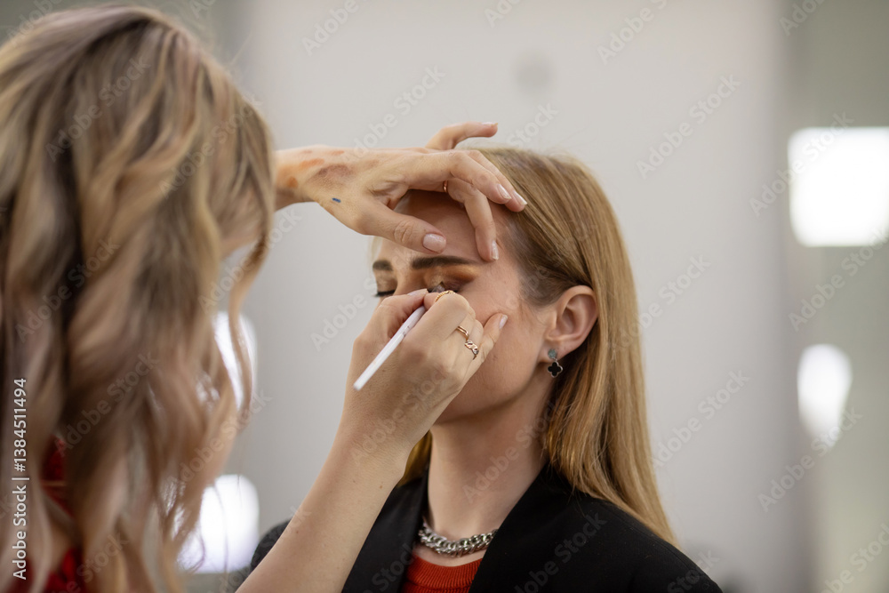 Fototapeta premium Professional visage artist applying makeup on woman's face in salon, closeup