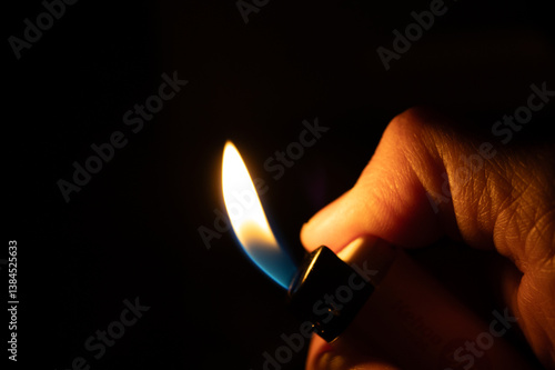 Obraz na plátně A flaming lighter in hand amidst the darkness