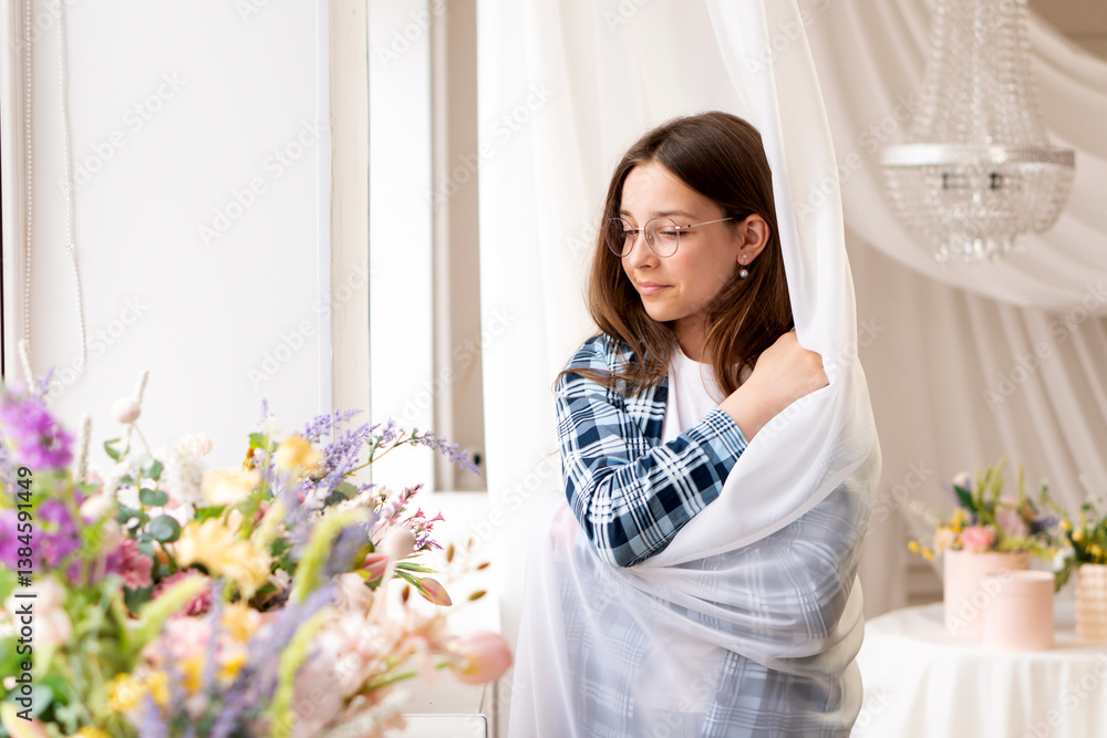 Teenage girl wrapped in sheer curtain by sunny window. Portrait female teen Teenage girl wrapped in sheer curtain by sunny window. Portrait female teen