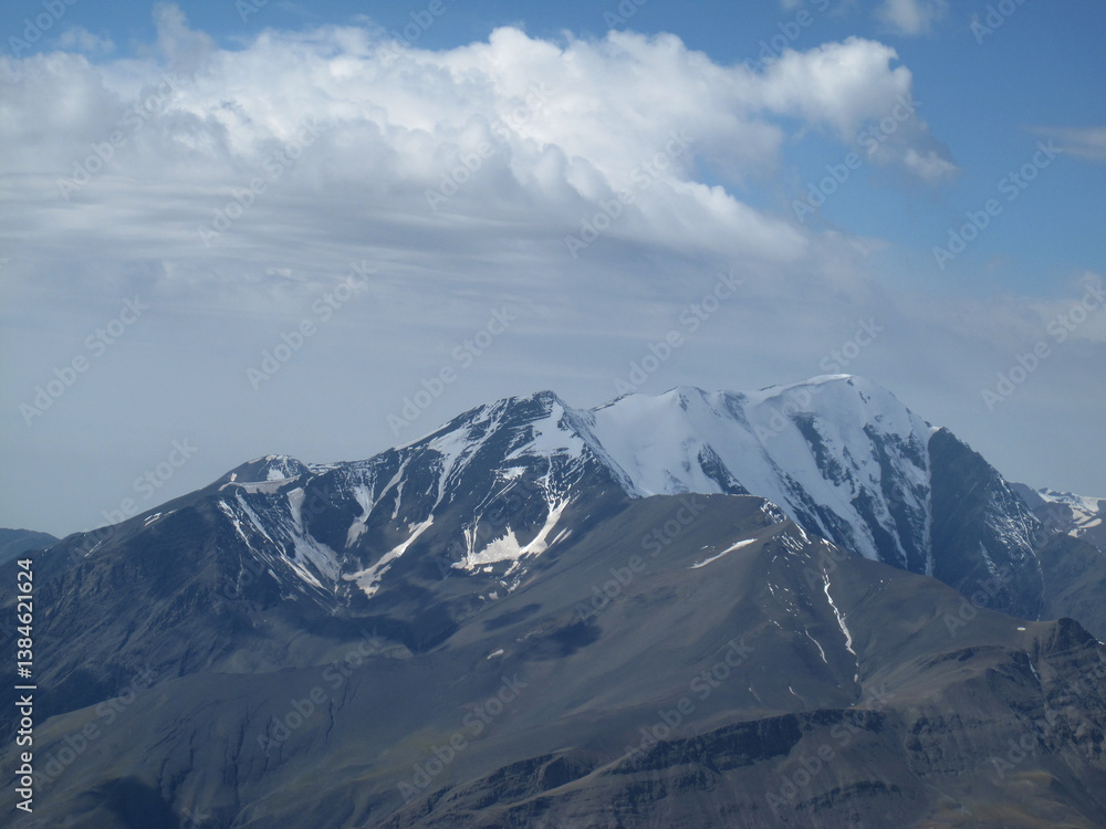 Pastures, hills, and cliffs on the slopes of the snow-capped Shahdag in the Caucasus Mountains Pastures, hills, and cliffs on the slopes of the snow-capped Shahdag in the Caucasus Mountains