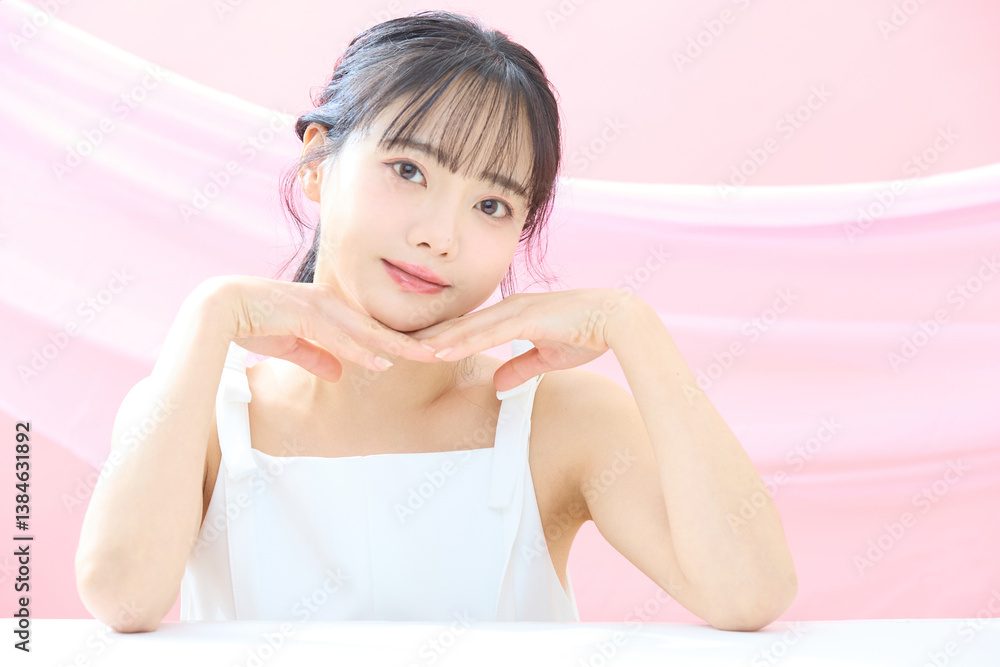Obraz premium ピンク背景で撮影をした若い女性の爽やかな美容イメージ
