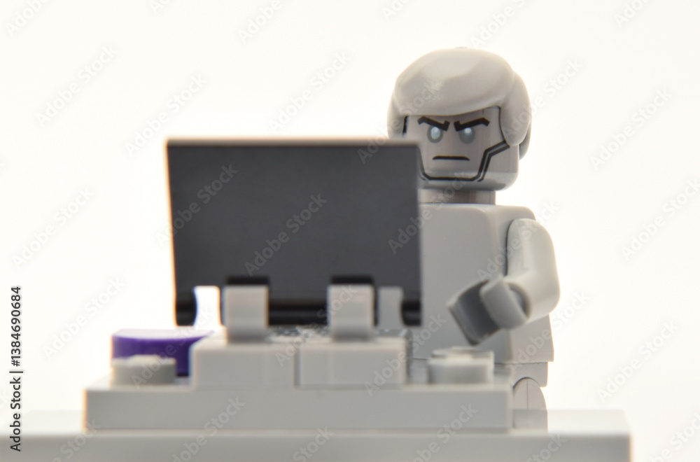 Obraz premium Editorial illustrative image of lego minifigure of artificial intelligence AI creature with computer online. Modern technology and popular children plastic toy