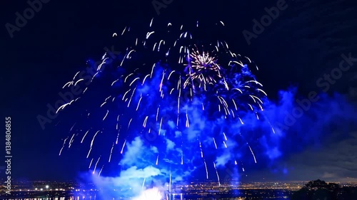 New Year's Eve Fireworks Over the City and River with Bright Glowing Lights in the Night Sky