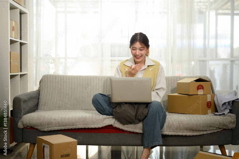 Fototapeta premium Young Businesswoman Using Laptop on Video Call Managing E-commerce Orders