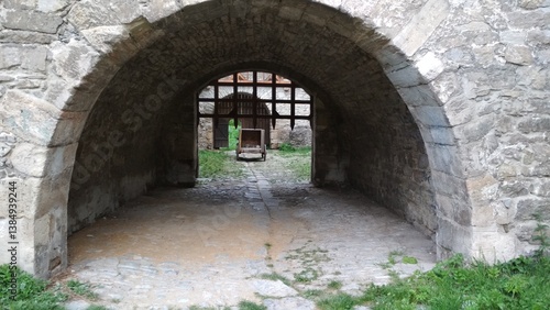 Arched entrance to the stone fortress and the descending portcullis