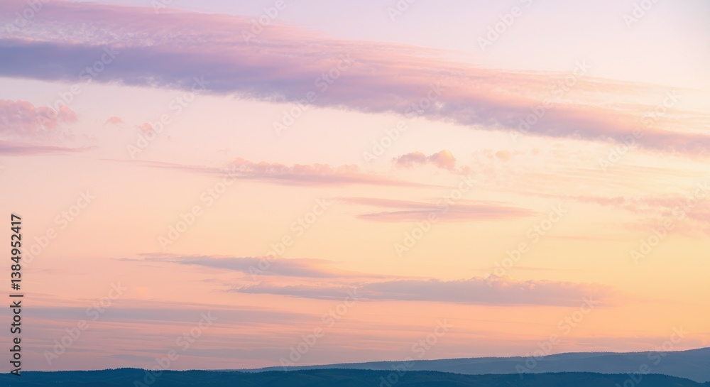 Fototapeta premium Pastel sky during sunset with soft clouds over mountain range