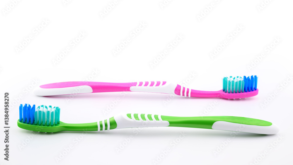 green and pink toothbrushes on white background close-up, side view green and pink toothbrushes on white background close-up, side view