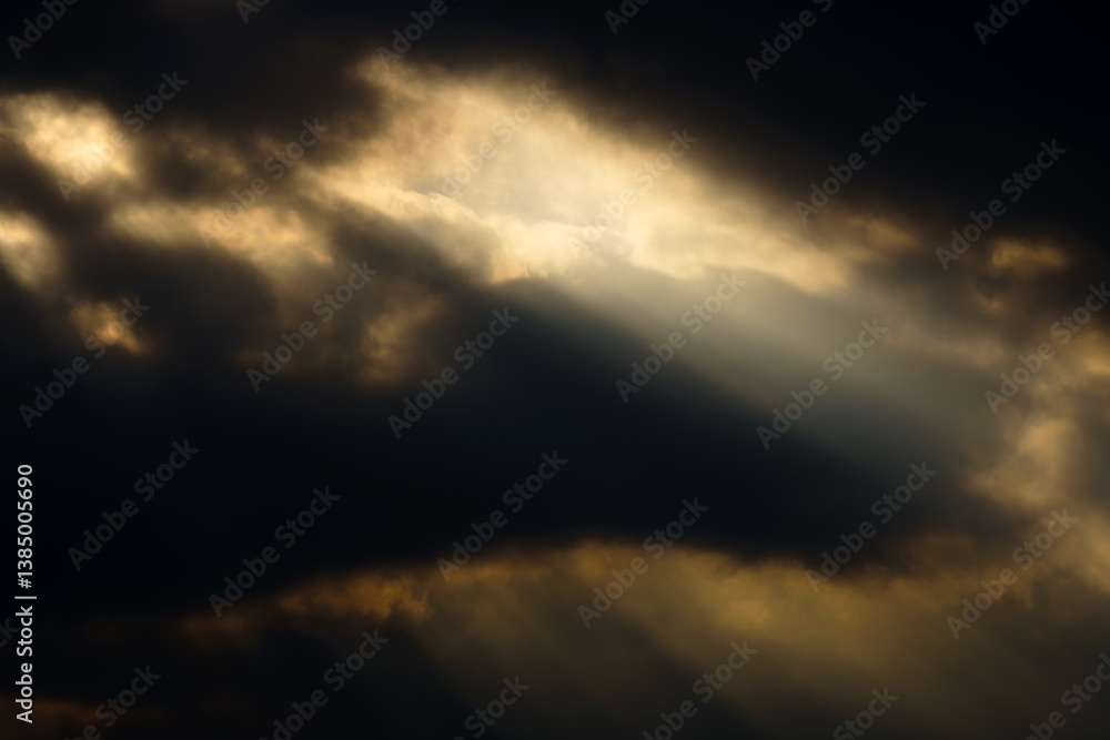 Obraz premium dark dramatic sky at sunset with sun rays through the clouds