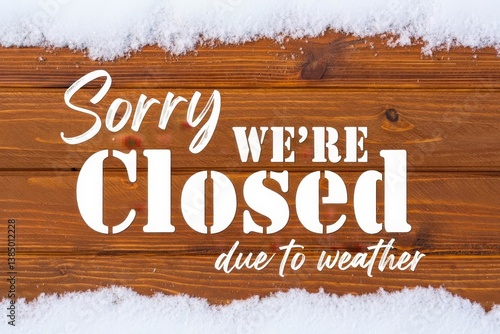 Sorry we are closed due to weather sign. Text and snow on wooden background.
