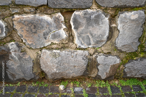 Obraz na płótnie Rough stone wall displays various gray hues with patches of moss, w salonie