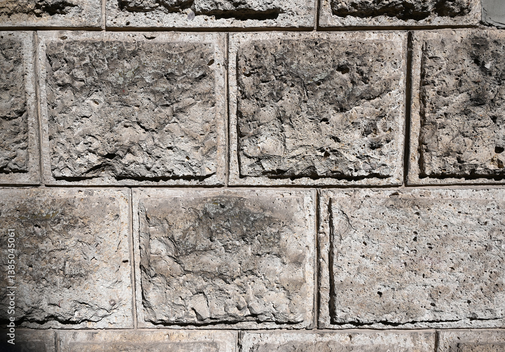 Textured concrete blocks form a sturdy wall in natural light during daytime