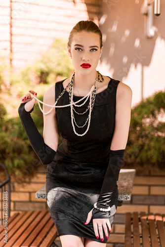 Young female model in black dress in Breakfast at Tiffany's style