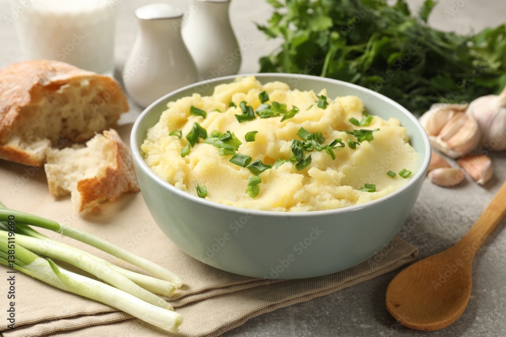 Delicious mashed potato with green onions served on grey table, closeup Delicious mashed potato with green onions served on grey table, closeup