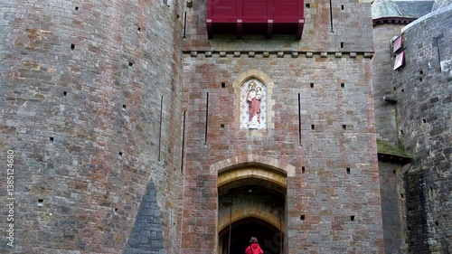 Woman standing in front of Red Castle or Castell Coch in Wales, tilt up shot.