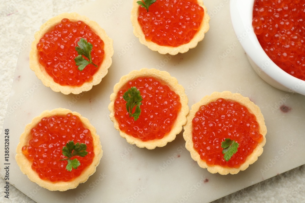 Tartlets with red caviar and parsley on beige background, top view Tartlets with red caviar and parsley on beige background, top view
