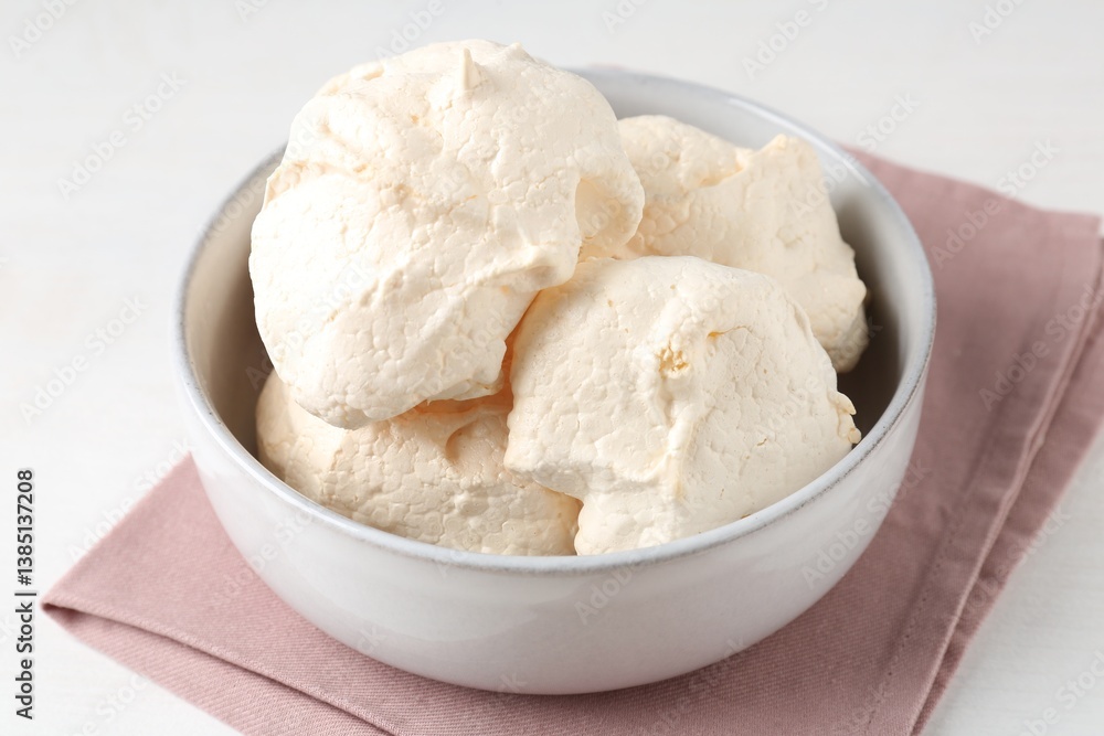 Delicious homemade meringue cookies in bowl on light table, closeup Delicious homemade meringue cookies in bowl on light table, closeup