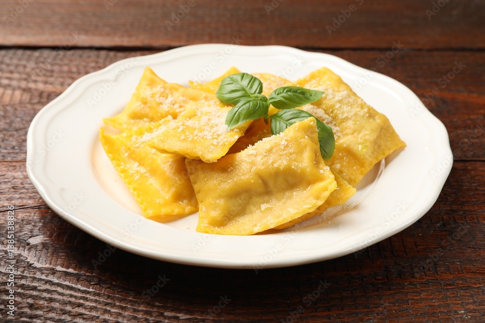 Delicious ravioli with parmesan cheese and basil on wooden table, closeup Delicious ravioli with parmesan cheese and basil on wooden table, closeup