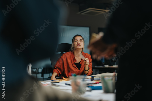 Colleagues brainstorm solutions in a collaborative office setting, analyzing and discussing project ideas to meet tight deadlines. A diverse team actively engages in a late evening strategy session.