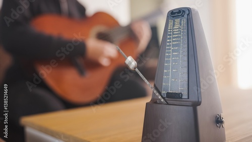 Fotografía Musician practicing guitar using traditional metronome for rhythm
