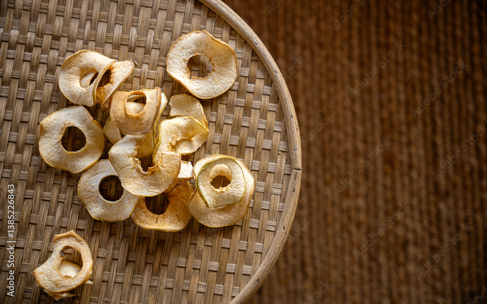 Dried apple slices on a woven tray in a natural setting Dried apple slices on a woven tray in a natural setting