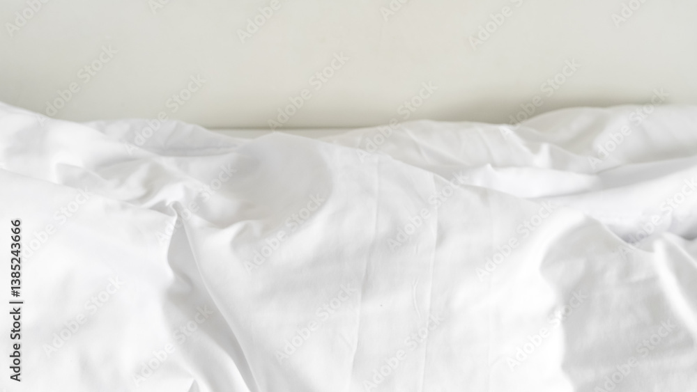 Obraz premium White bedding with soft folds and neutral tones for cozy interior aesthetics
