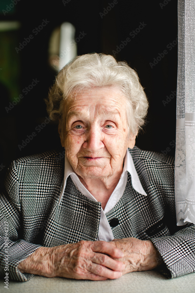 A portrait of a kind elderly woman in a business suit, her wrinkled hands resting gently, radiating warmth and dignity.
