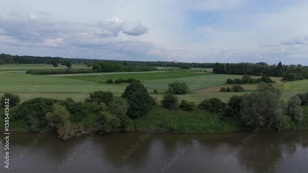 Aerial video of a meandering riverbank lined with green fields and hedgerows under soft daylight. Aerial video of a meandering riverbank lined with green fields and hedgerows under soft daylight.
