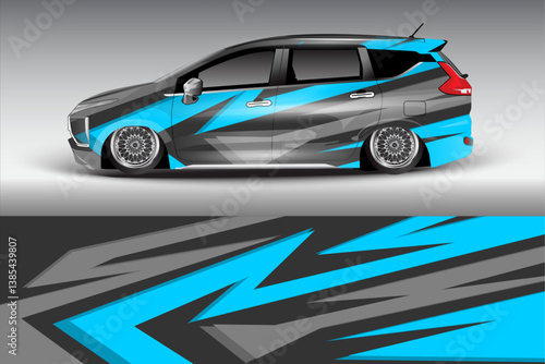 Stylish modified car with striking blue and gray graphics, parked on a smooth surface, showcasing its sleek design
