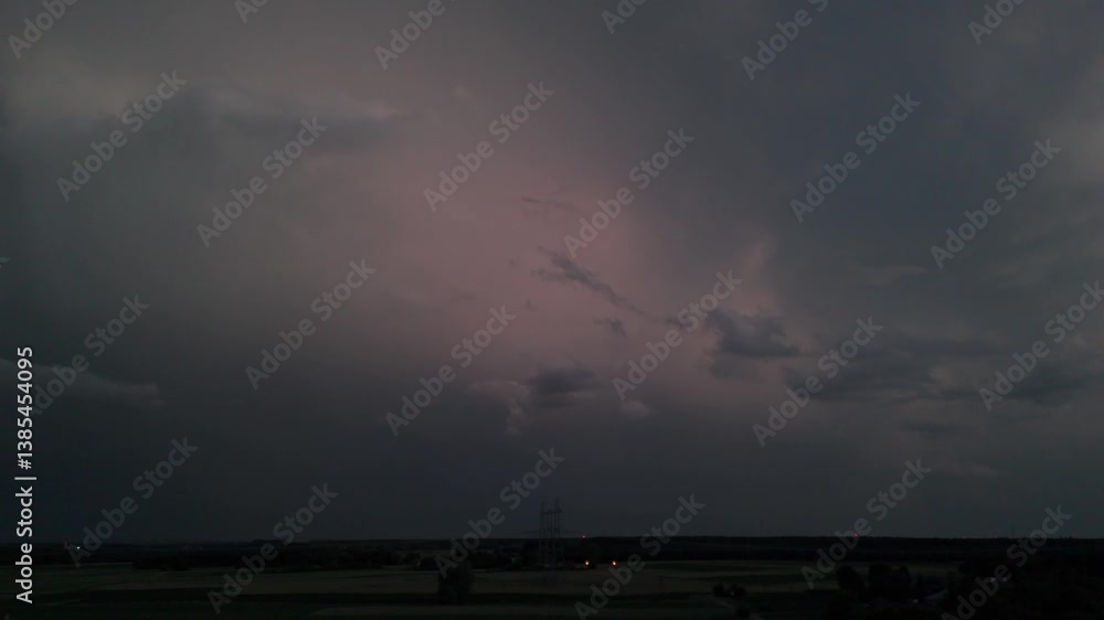 Aerial video capturing lightning illuminating dark storm clouds over flat fields at dusk. Aerial video capturing lightning illuminating dark storm clouds over flat fields at dusk.