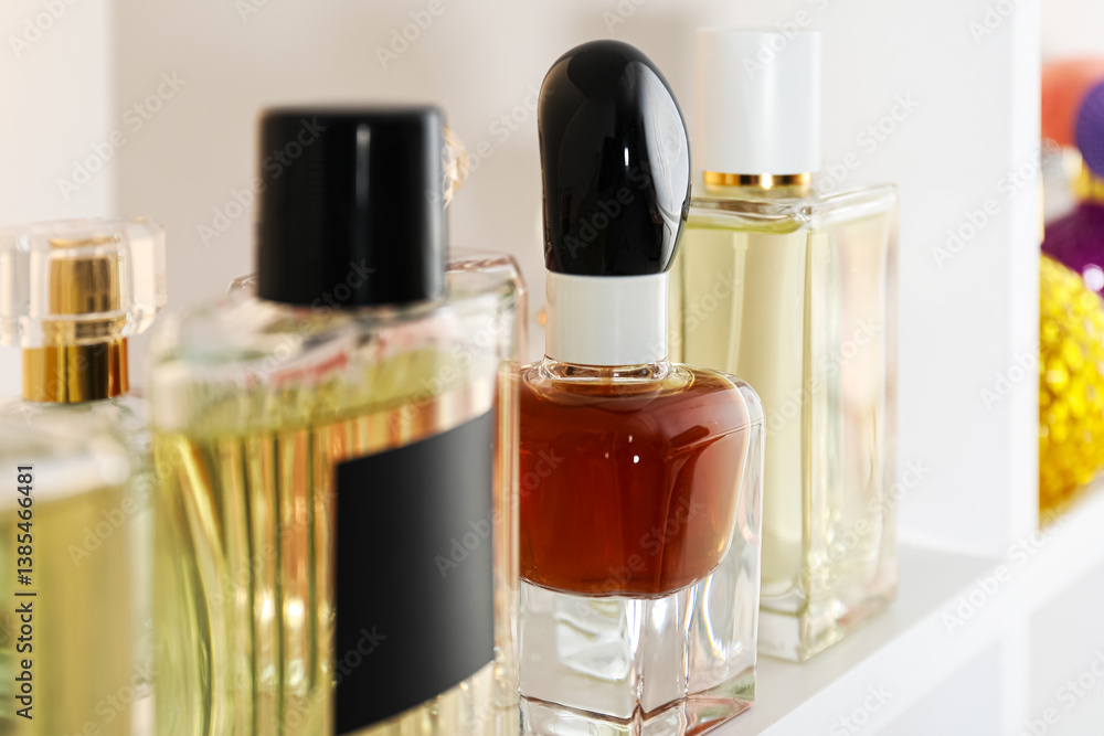 Different bottles of luxury perfume on shelf in store, closeup Different bottles of luxury perfume on shelf in store, closeup